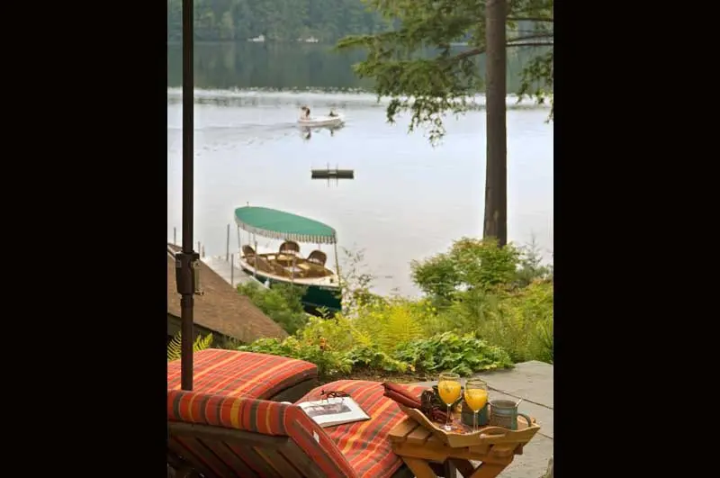 View from lodge patio overlooking lake with a boat at shore