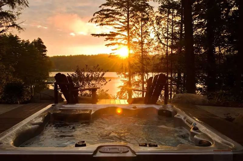 Hot tub overlooking lake during sunset