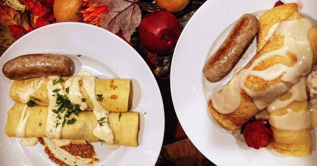 two breakfast plates with crepes and sausage